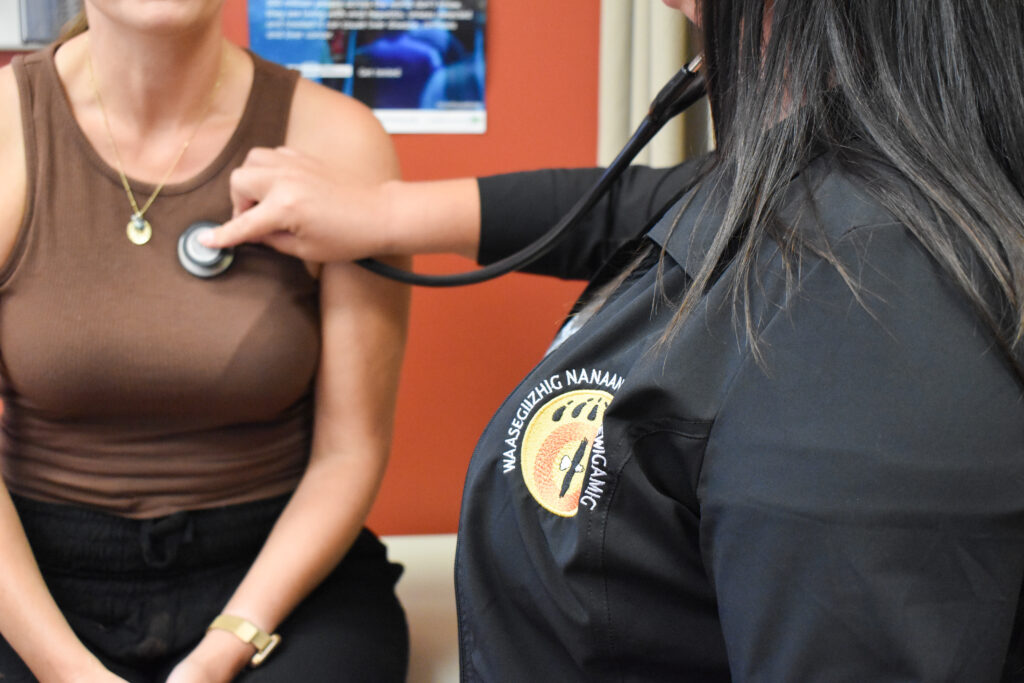 a nurse with stethoscope, checking the heartbeat of a patient