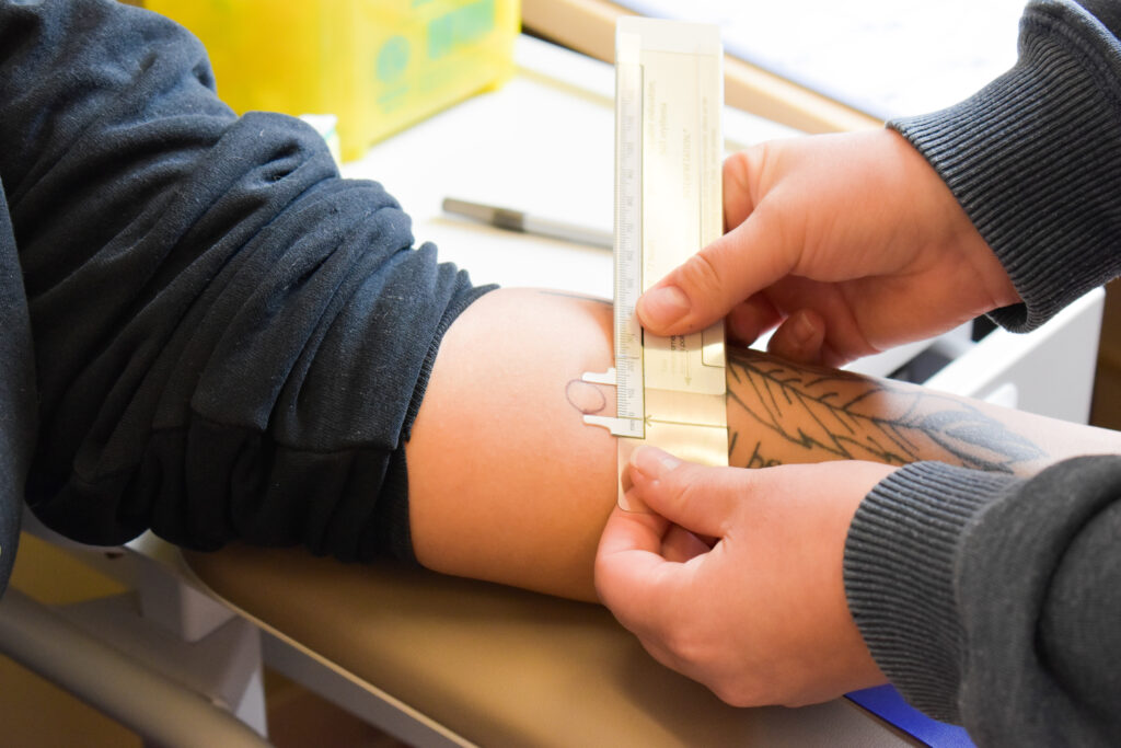 a person measuring the tattoo design on other person's hand
